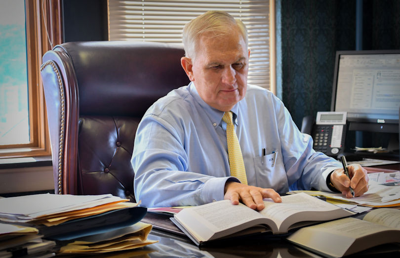 Image of William C. Brewer working at his desk, an experienced WV trial lawyer clients return to for criminal defense, commercial litigation, business matters, personal injury, and more.