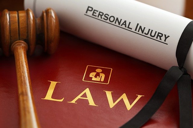 Photo of a scroll titled “personal injury” next to a gavel, representing how a Morgantown personal injury attorney from William C. Brewer & Associates, PLLC fights to recover as much compensation from personal injuries as possible. 